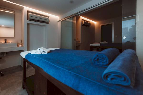 Massagebett mit blauen Tüchern in einem modernen Raum