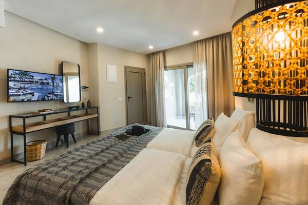 Schlafzimmer im Eliros Mare Hotel mit einem Doppelbett, Fernseher und Schreibtisch.
