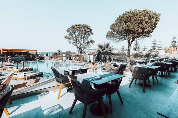 Terrasse des Eliros Mare Hotels mit Tischen, Stühlen und Blick auf den Pool