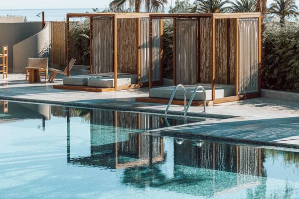 Pool-Lounge-Bereich des Eliros Mare Hotels mit stilvollen Sonnenschirmen und Sesseln.