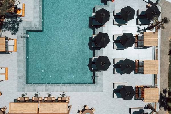 Luftbild vom Poolbereich des Eliros Mare Hotels mit Liegestühlen und Sonnenschirmen.