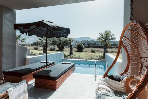 Terrasse mit Liegen und Umbrella beim Eliros Mare Hotel.
