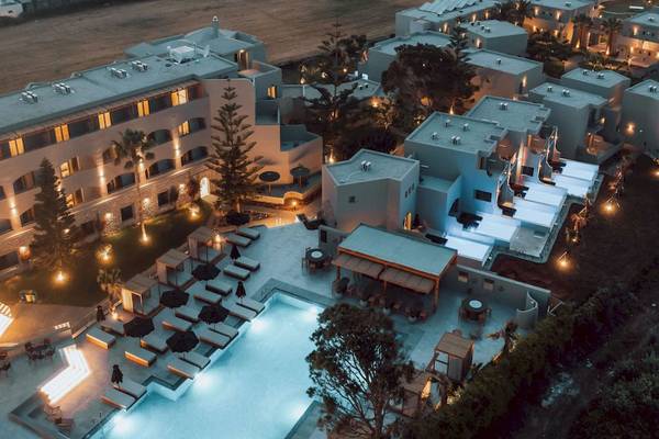 Luftaufnahme des Eliros Mare Hotels bei Nacht mit Pool und Beleuchtung.