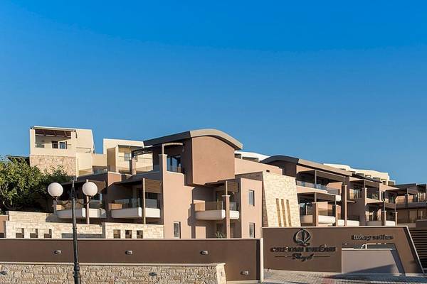 Haupteingang des Cretan Dream Resort & Spa mit mehreren Stockwerken und einem Logo