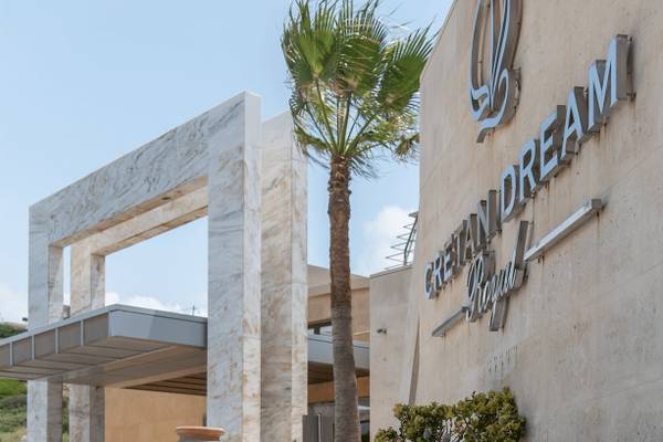 Eingang des Cretan Dream Resort & Spa mit Palme und moderner Architektur