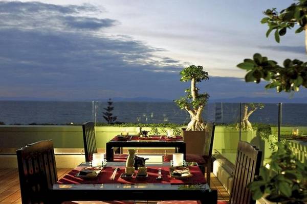 Terrasse des Sheraton Rhodes Resort mit Meerblick und abendlichem Himmel.