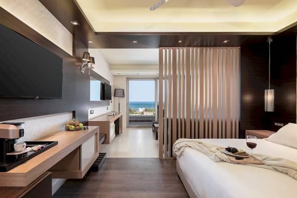 Innenansicht eines Zimmers im Cretan Dream Resort & Spa mit Blick auf das Meer.