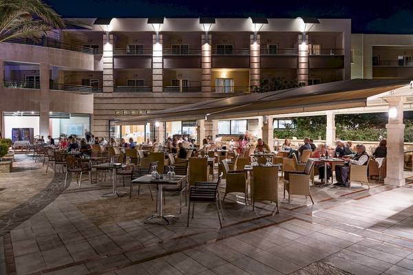 Ein Hotelrestaurant bei Nacht mit Gästen, die an Tischen sitzen und essen.