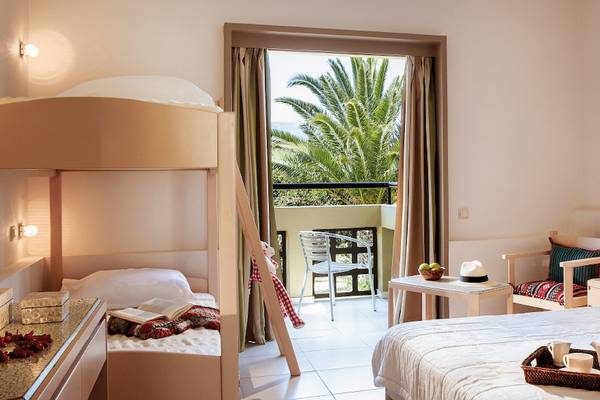 Doppelzimmer im Grecotel Meli Palace mit Blick auf eine Terrasse und eine Palme