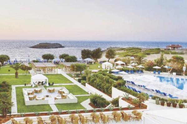 Gesamtausblick auf das Grecotel Meli Palace Hotel Resort mit Pool, Liegestühlen und Meer.