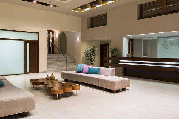 Empfangsbereich des Chrissi Amoudia Hotels mit Couchgarnitur und Treppen.