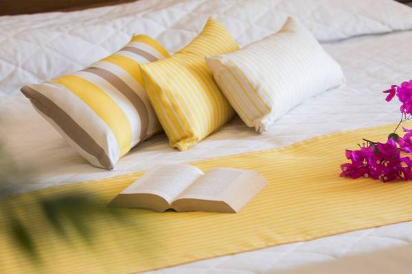 Hotelbett mit Kissen und Büchern von Chrissi Amoudia