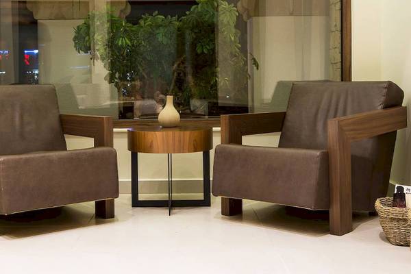 Loungebereich im Chrissi Amoudia Hotel mit zwei Ledersesseln und einem Tisch.