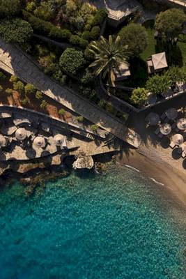 Luftaufnahme des Minos Palace Hotel & Suites am Strand mit Palmen und Sonnenschirmen.