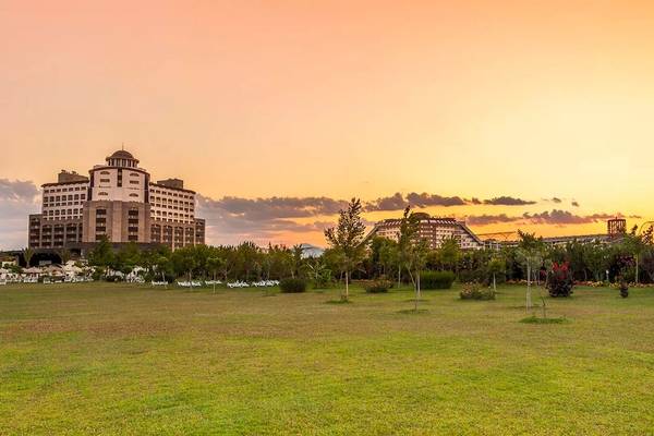 Melas Lara Hotel bei Sonnenuntergang mit Gebäuden und Rasen