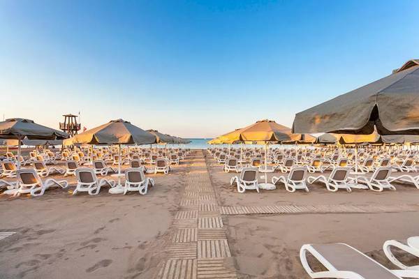 Strand des Melas Lara Hotels mit vielen Sonnenliegen und Sonnenschirmen