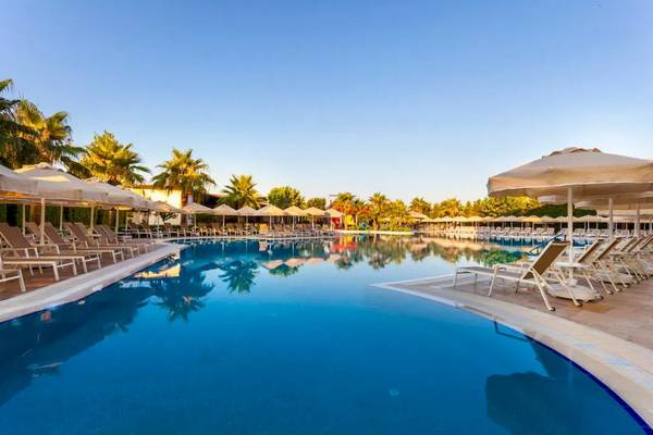 Außenpool mit Liegestühlen und Sonnenschirmen im Melas Lara Hotel