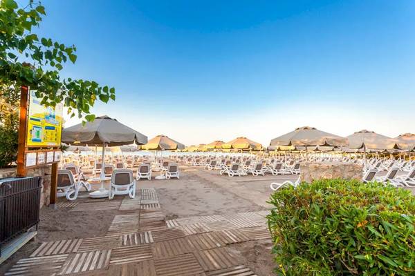 Strand des Melas Lara Hotels mit vielen Sonnenliegen und Sonnenschirmen.