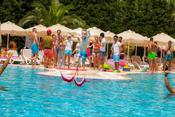 Im Melas Lara Hotel springen Kinder über Hüpfschlingen im Schwimmbad.