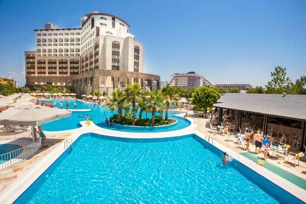 Außenbereich des Melas Lara Hotels mit Swimmingpool und vielen Gästen