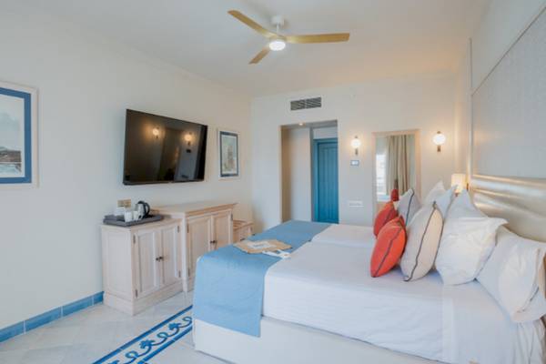 Schlafzimmer im LIVVO Volcan Lanzarote Hotel mit Doppelbett, Fernseher und Nachttisch.