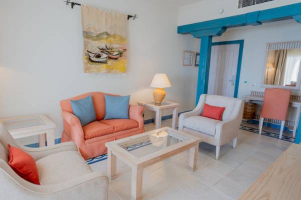 Wohnzimmer im LIVVO Volcan Lanzarote Hotel mit zwei Sofas, einem Tisch, einer Lampe und einer Wanddekoration.