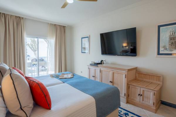 Zimmer im LIVVO Volcan Lanzarote Hotel mit Doppelbett, Fernseher und Balkon.