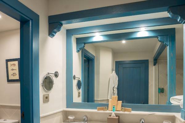 Badezimmer im LIVVO Volcan Lanzarote Hotel mit blauen Akzenten und einem Spiegel.