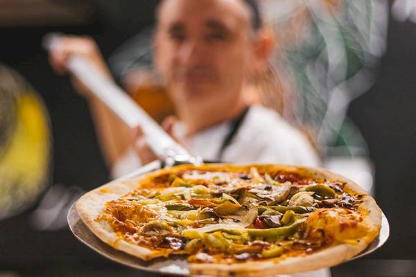 LIVVO Volcan Lanzarote Hotel-Küchenpersonal hält eine Pizza auf einem Pizzaliefertraeger