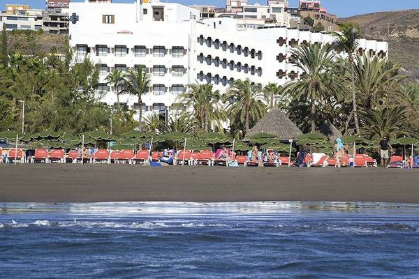 Strand mit Hotel Corallium Beach von Lopesan Hotels, Liegestuhlreihen und Palmen