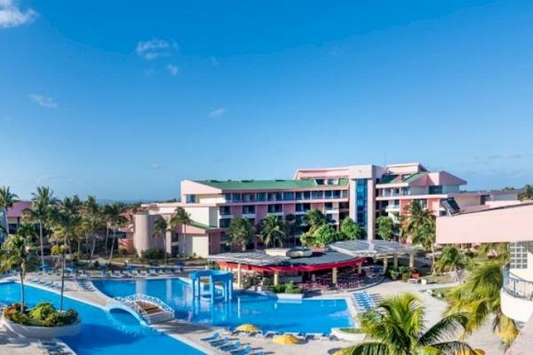 Außenbereich des Muthu Playa Varadero Hotels mit Swimmingpool, Sonnenliegen und Gebäuden