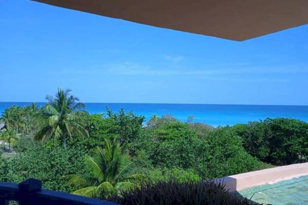 Aussicht auf den Ozean vom Muthu Playa Varadero Hotel aus mit blauem Himmel und grüner Vegetation.