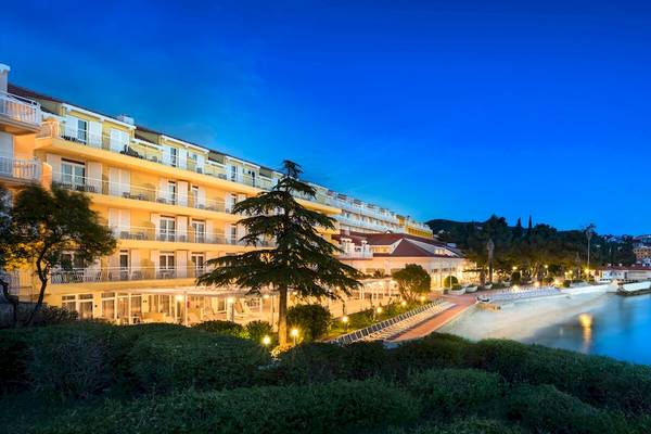 Remisens Hotel Epidaurus bei Nacht mit Beleuchtung und Meer im Hintergrund