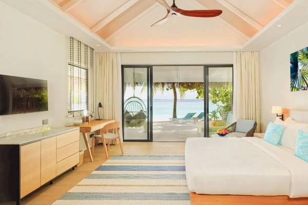 Ein Schlafzimmer im Nova Maldives Hotel mit Blick auf das Meer und eine Terrasse.