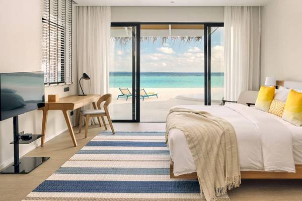 Hotelzimmer im Nova Maldives mit Meerblick, Bett, Schreibtisch und Fernseher.