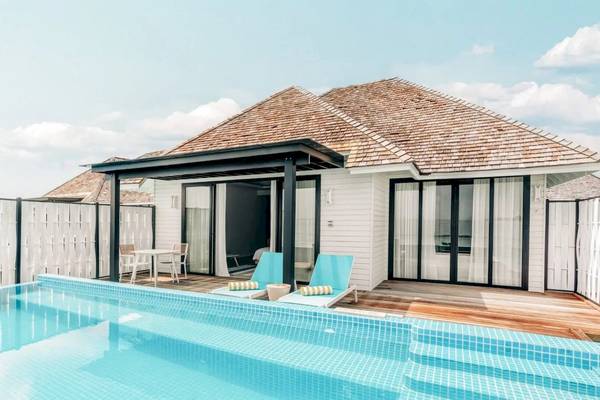 Ein Swimmingpool und eine Villa im Hotel Nova Maldives.