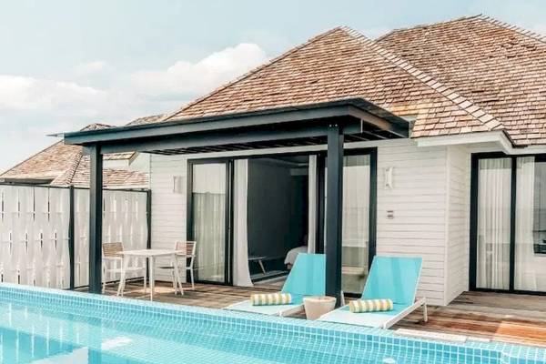 Außenbereich des Nova Maldives Hotels mit Pool und Lounge-Bereich.