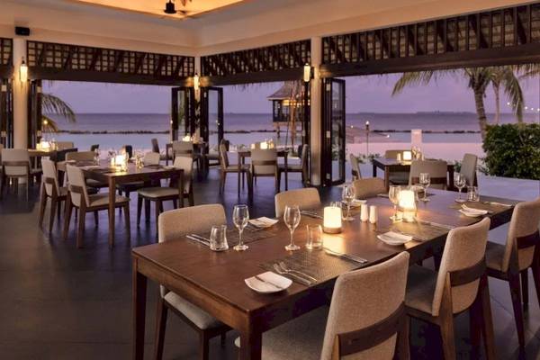 Innenansicht des Restaurants im Nova Maldives Hotel mit Blick auf das Meer.