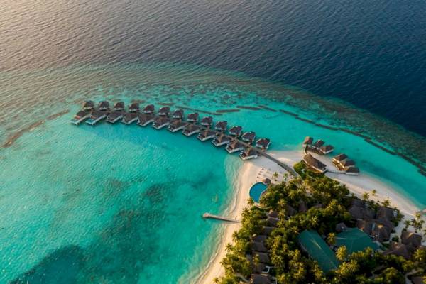 Luftaufnahme des Nova Maldives Resorts mit Wasservillen und Strand