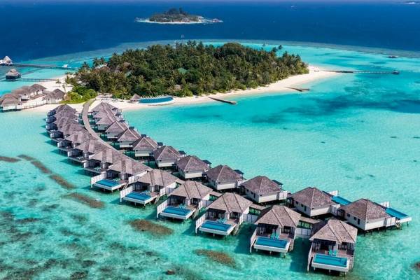 Luftaufnahme des Nova Maldives Resorts mit Wasservillen und türkisfarbenem Ozean