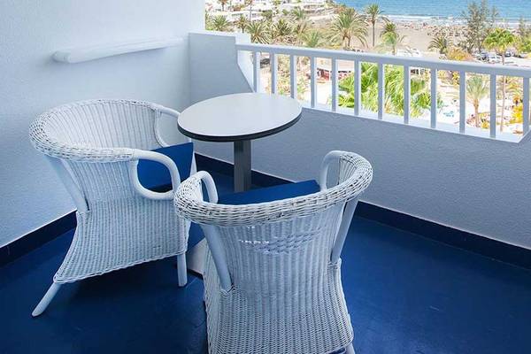 Balkon im Corallium Beach Hotel mit Tisch und Stühlen und Blick auf den Strand