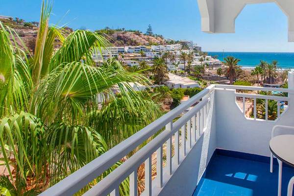 Aussicht vom Balkon des Corallium Beach by Lopesan Hotels auf die Stadt und das Meer.