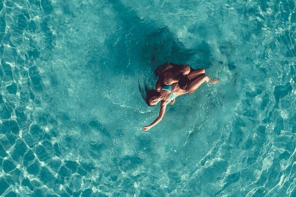 Zwei Frauen schwimmen im Pool des Mitsis Selection Rinela Hotels.