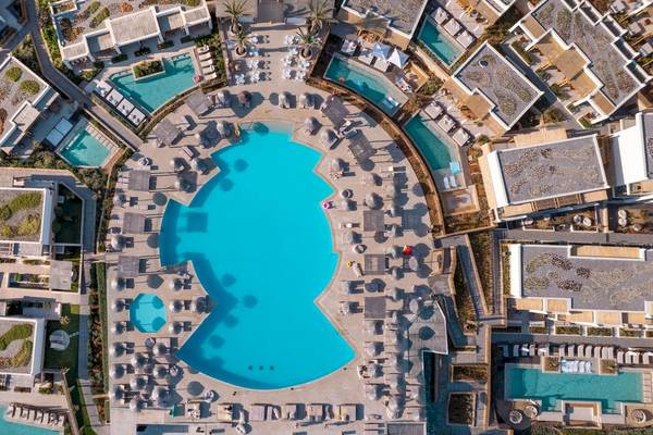 Luftaufnahme des Mitsis Selection Rinela Hotels mit mehreren Pools und Liegebereichen.