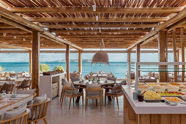 Innenansicht des Restaurants im Mitsis Selection Rinela Hotel mit Blick auf das Meer.