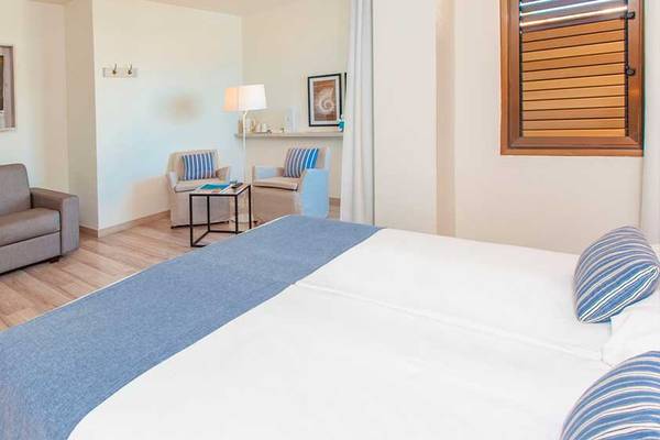 Hotelzimmer im Corallium Beach by Lopesan Hotels mit Bett, Sofa und Fernseher.