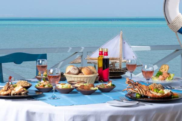 Meerblick-Tisch im Mövenpick Resort & Spa El Gouna mit vielen Gerichten, Gläsern und Dekoration.