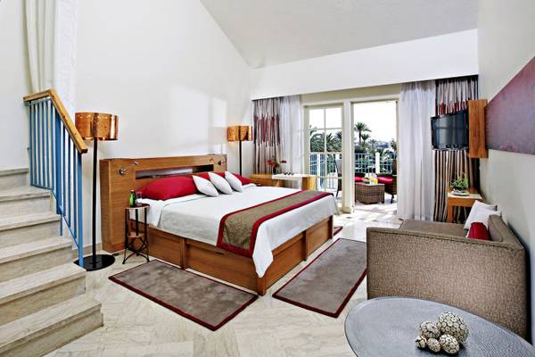 Hotelzimmer im Mövenpick Resort & Spa El Gouna mit Bett, Sofa, Tisch und Balkon