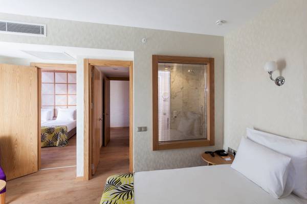Innenansicht eines Zimmers im Defne Defnem Hotel mit Bett, Nachttisch und Badezimmer mit Dusche