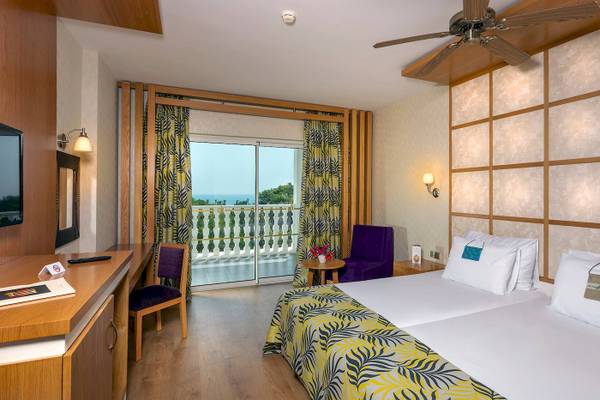 Zimmer im Defne Defnem Hotel mit Blick auf den Balkon und das Meer.